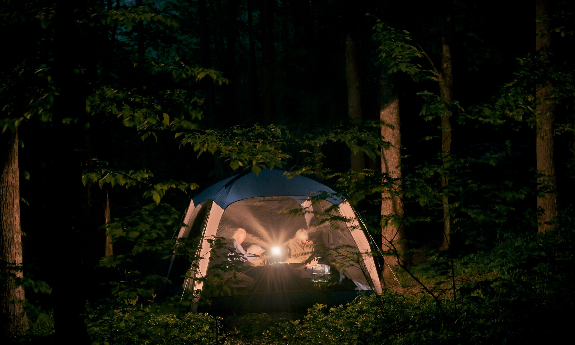 Couple reading by lantern light - Great Smoky Mountains National Park, Tennessee